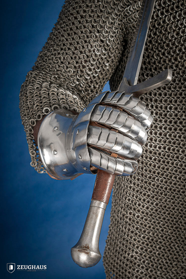 A pair of polished steel gauntlets from 1350-1415, showcasing intricate craftsmanship and an hourglass design for flexibility.