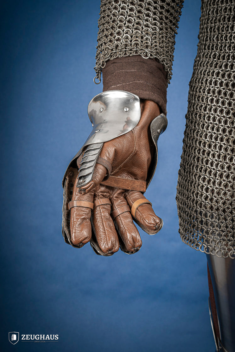 A pair of polished steel gauntlets from 1350-1415, showcasing intricate craftsmanship and an hourglass design for flexibility.