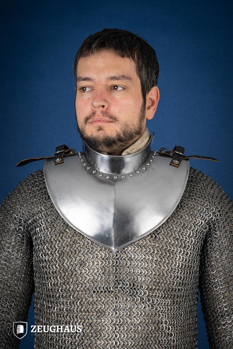 Polished gorget with stand-up collar, featuring crimped edges and leather straps, designed for neck protection and flexibility.