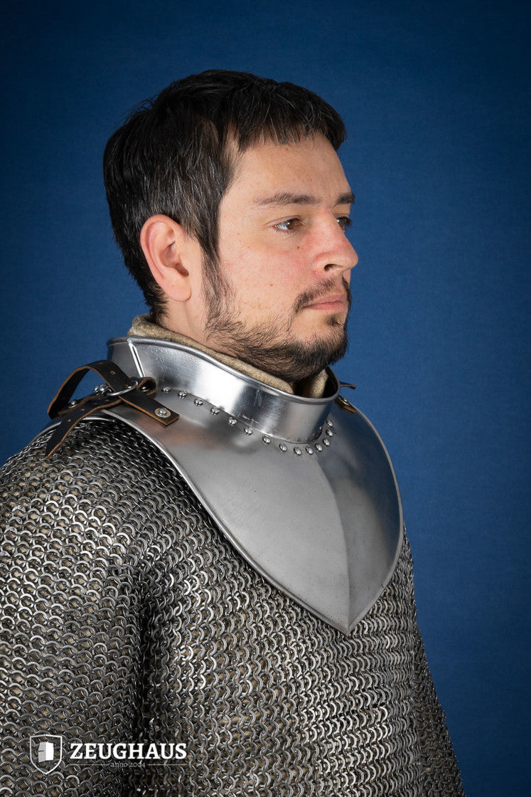 Polished gorget with stand-up collar, featuring crimped edges and leather straps, designed for neck protection and flexibility.
