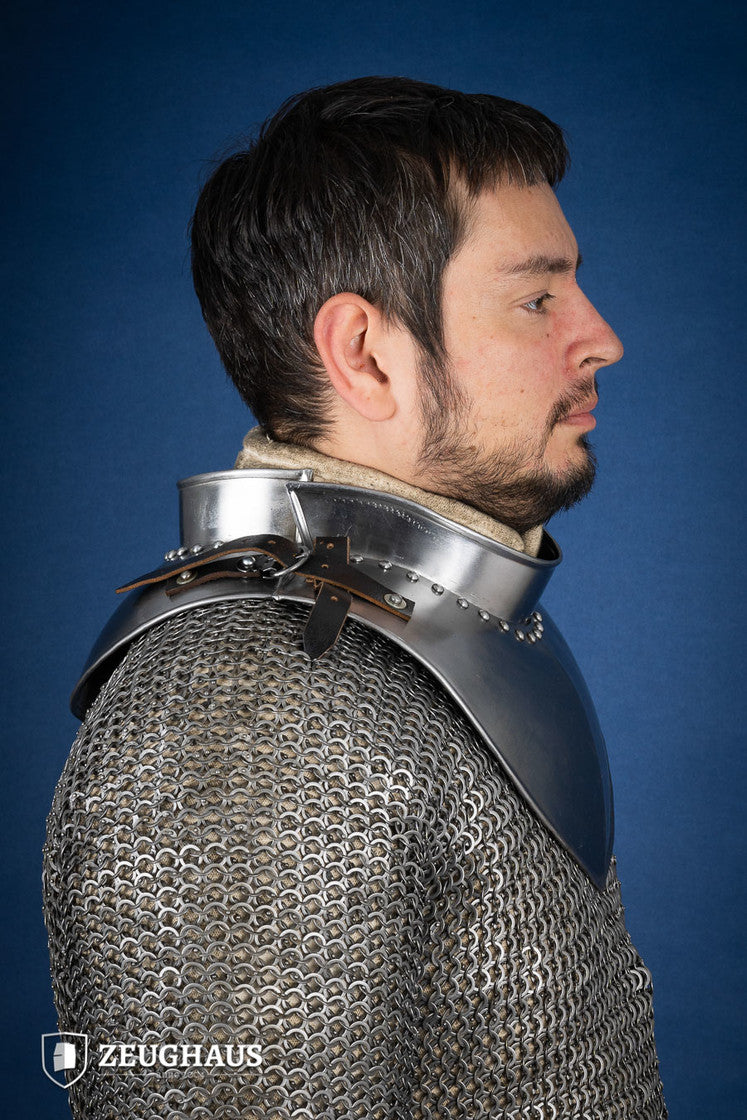 Polished gorget with stand-up collar, featuring crimped edges and leather straps, designed for neck protection and flexibility.