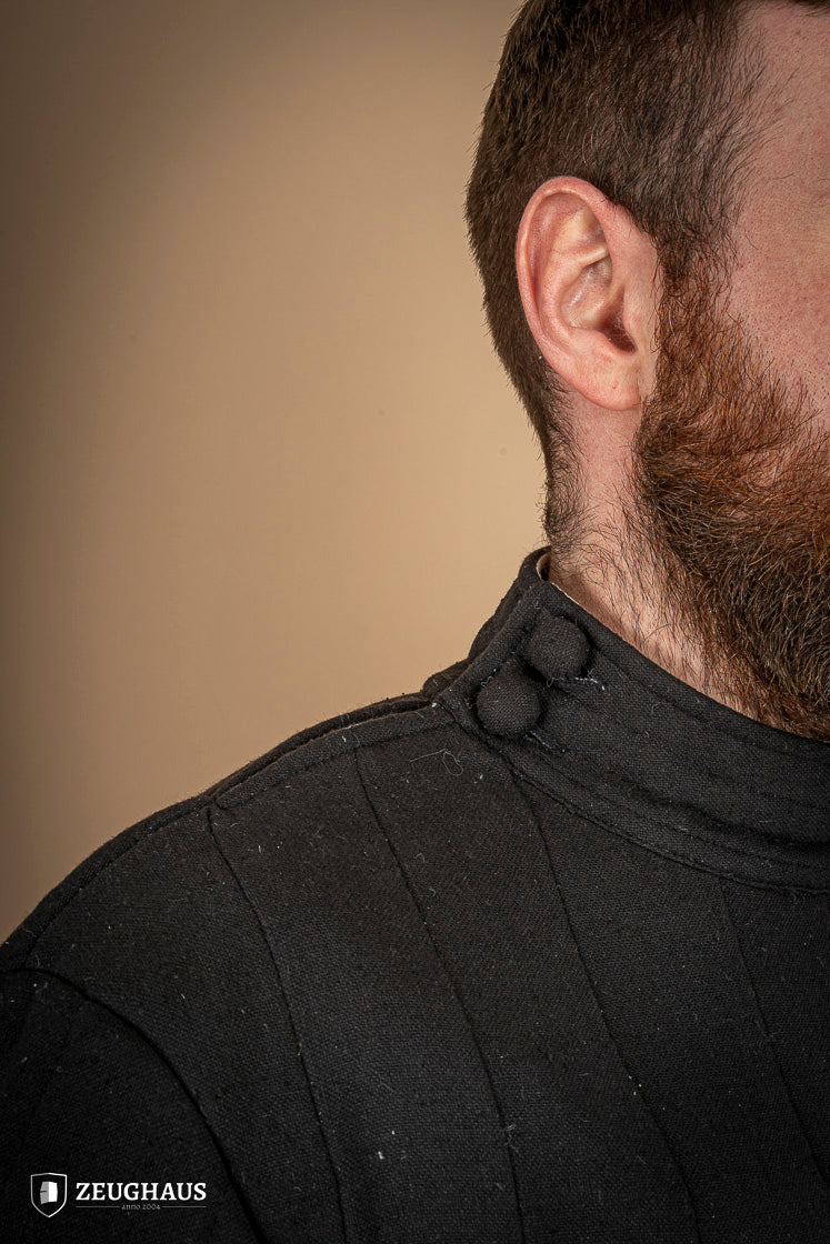 Infantry Gambeson Black featuring neck button closure and slits for mobility, made of 100% cotton with linen pattern.