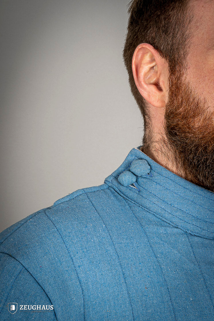 Infantry Gambeson Blue featuring neck button closure and slits for mobility, made of 100% cotton with linen pattern.
