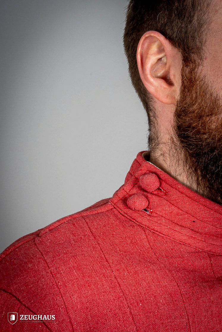 Infantry Gambeson Red featuring a neck button closure, slits for mobility, and made of 100% cotton with a linen pattern.