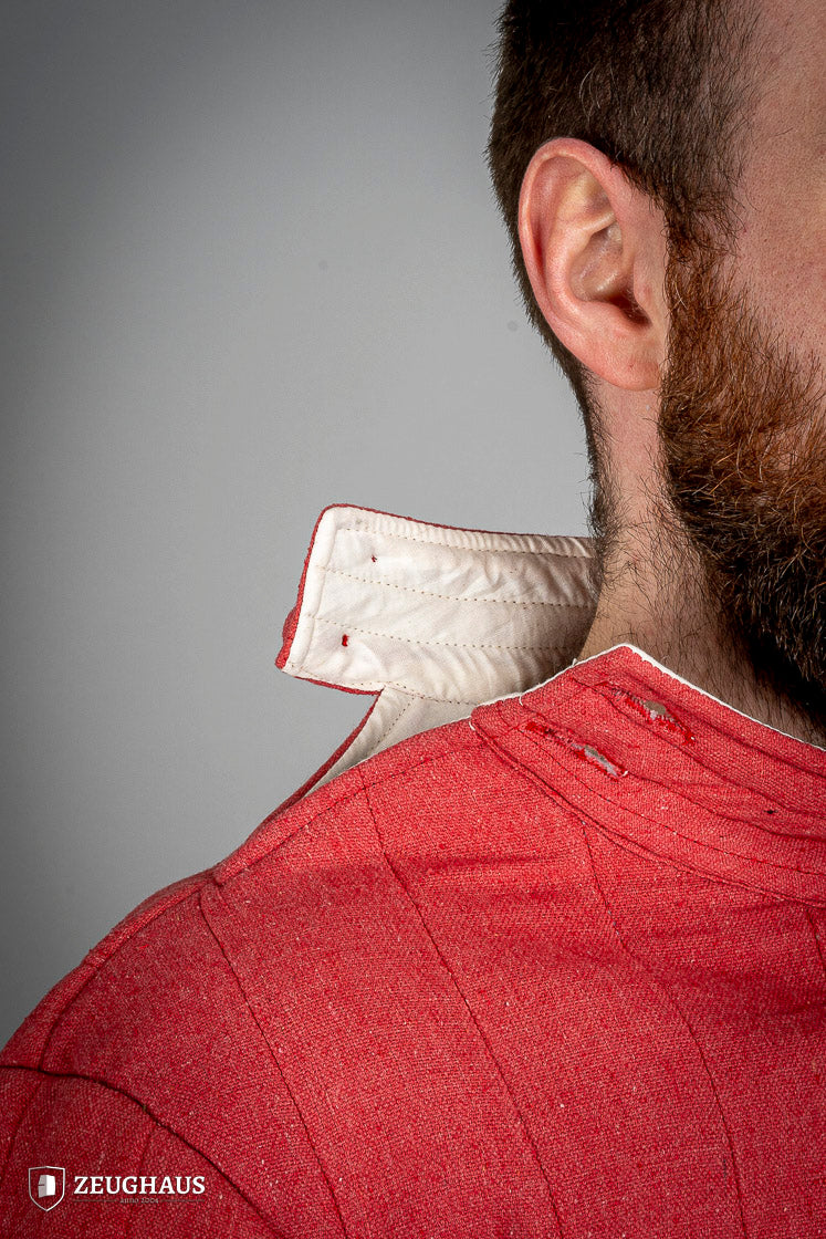 Infantry Gambeson Red featuring a neck button closure, slits for mobility, and made of 100% cotton with a linen pattern.