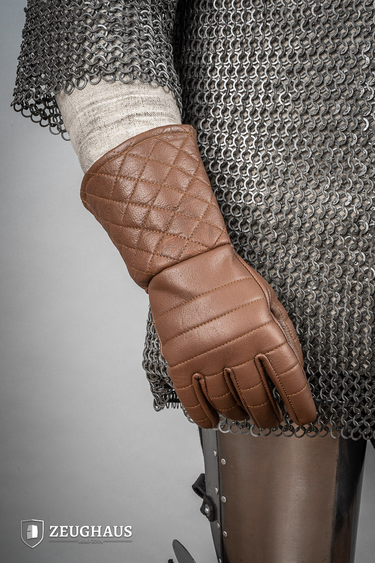 A pair of brown leather gloves designed for martial arts, showcasing natural imperfections and unique color variations.