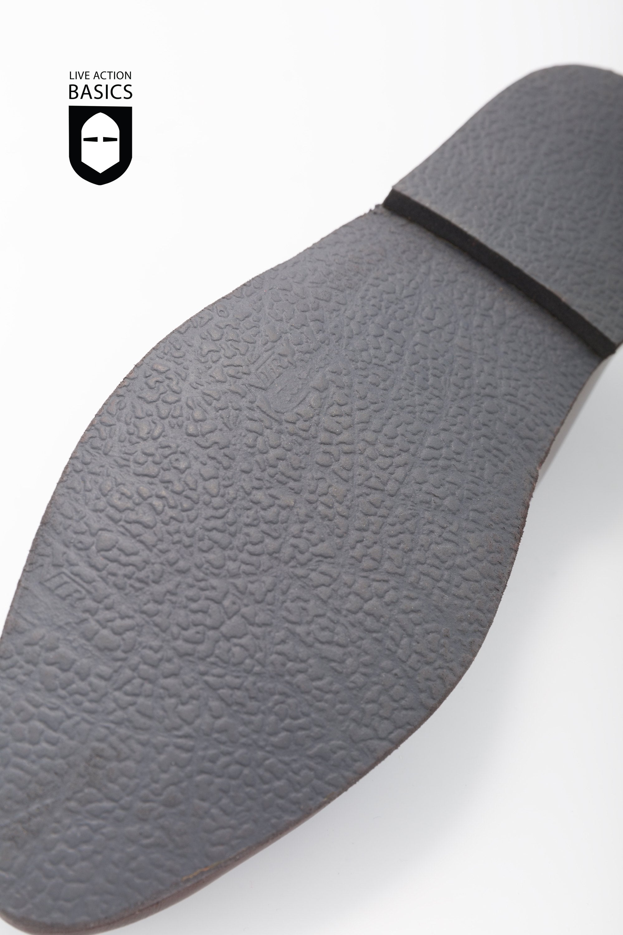 A pair of dark brown medieval shoes made from high-quality leather, featuring a cleated sole and leather strip fastening.