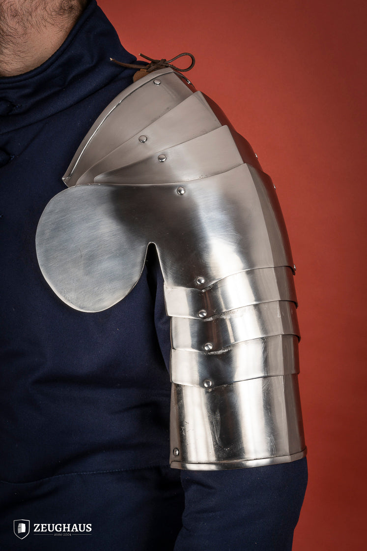 Polished steel pauldrons from 1400-1450, featuring a besagew for added stability and protection, showcasing a historical design.
