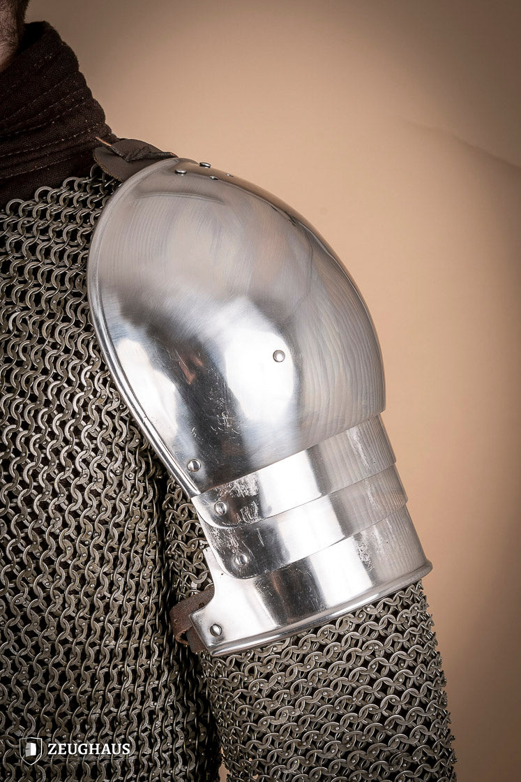 Polished 1460 pauldrons made of 1.6mm steel, showcasing a satin finish and handcrafted details for medieval armor enthusiasts.