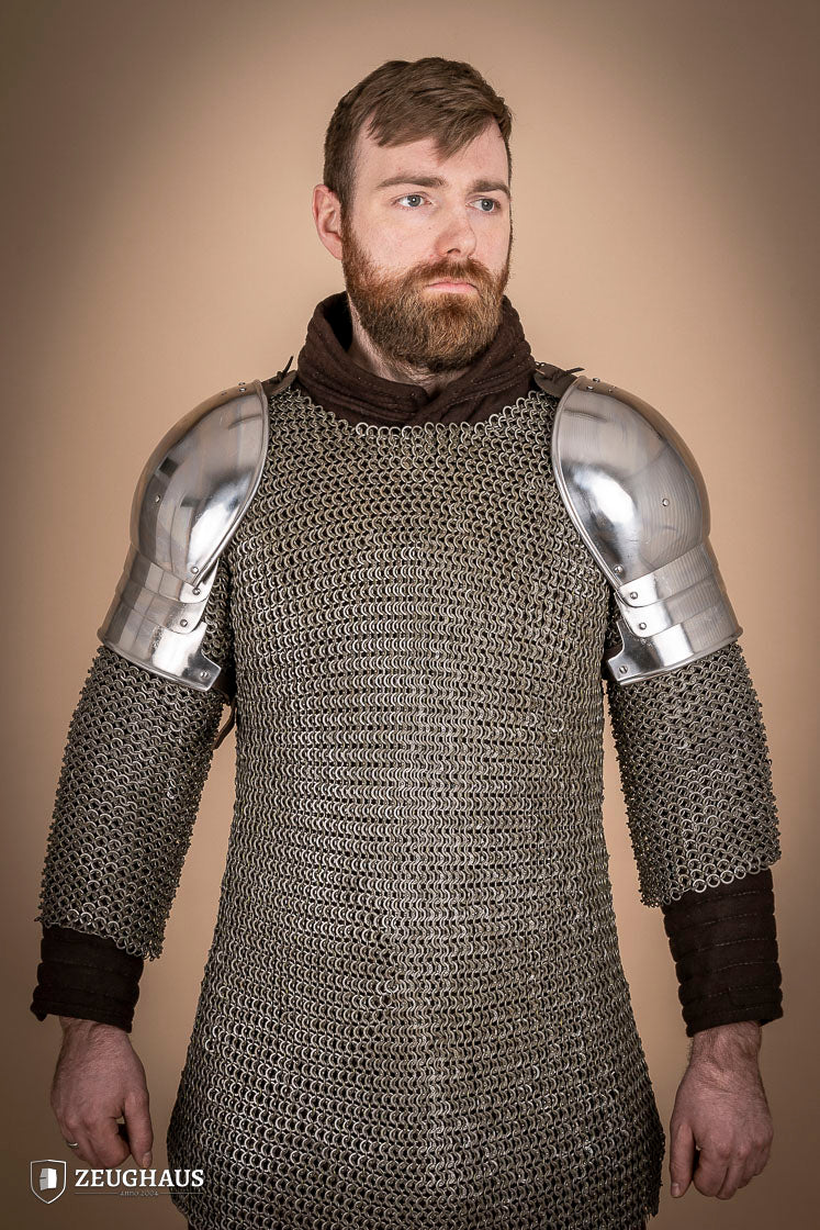 Polished 1460 pauldrons made of 1.6mm steel, showcasing a satin finish and handcrafted details for medieval armor enthusiasts.
