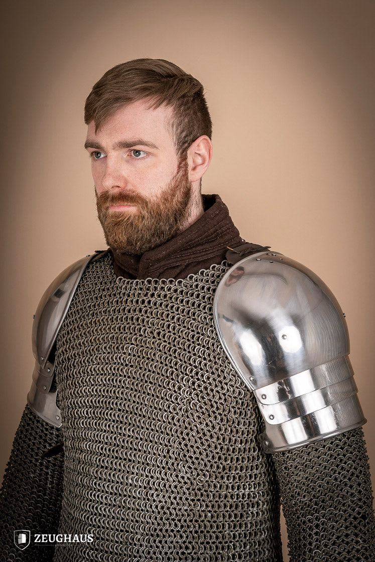 Polished 1460 pauldrons made of 1.6mm steel, showcasing a satin finish and handcrafted details for medieval armor enthusiasts.