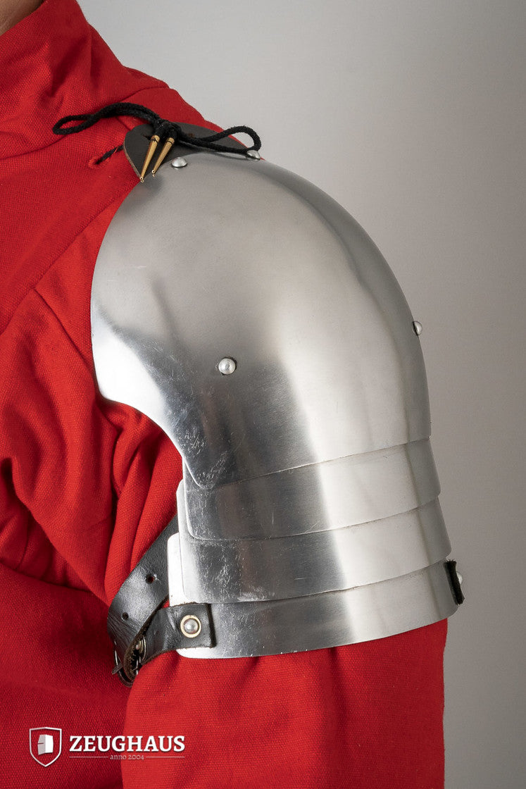 Polished 14th Century pauldrons made of 1.6mm steel, showcasing intricate design and sturdy leather cords for attachment.