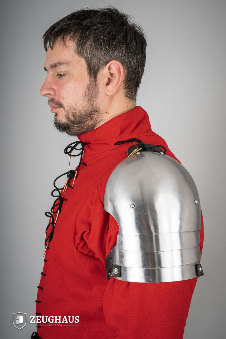 Polished 14th Century pauldrons made of 1.6mm steel, showcasing intricate design and sturdy leather cords for attachment.