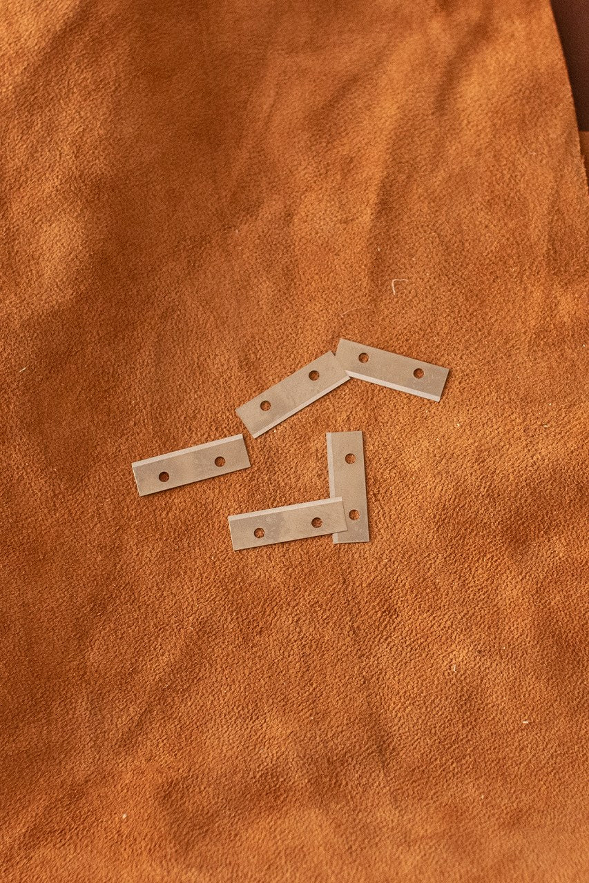 Five sharp replacement blades for strap cutter, designed for precision cutting.
