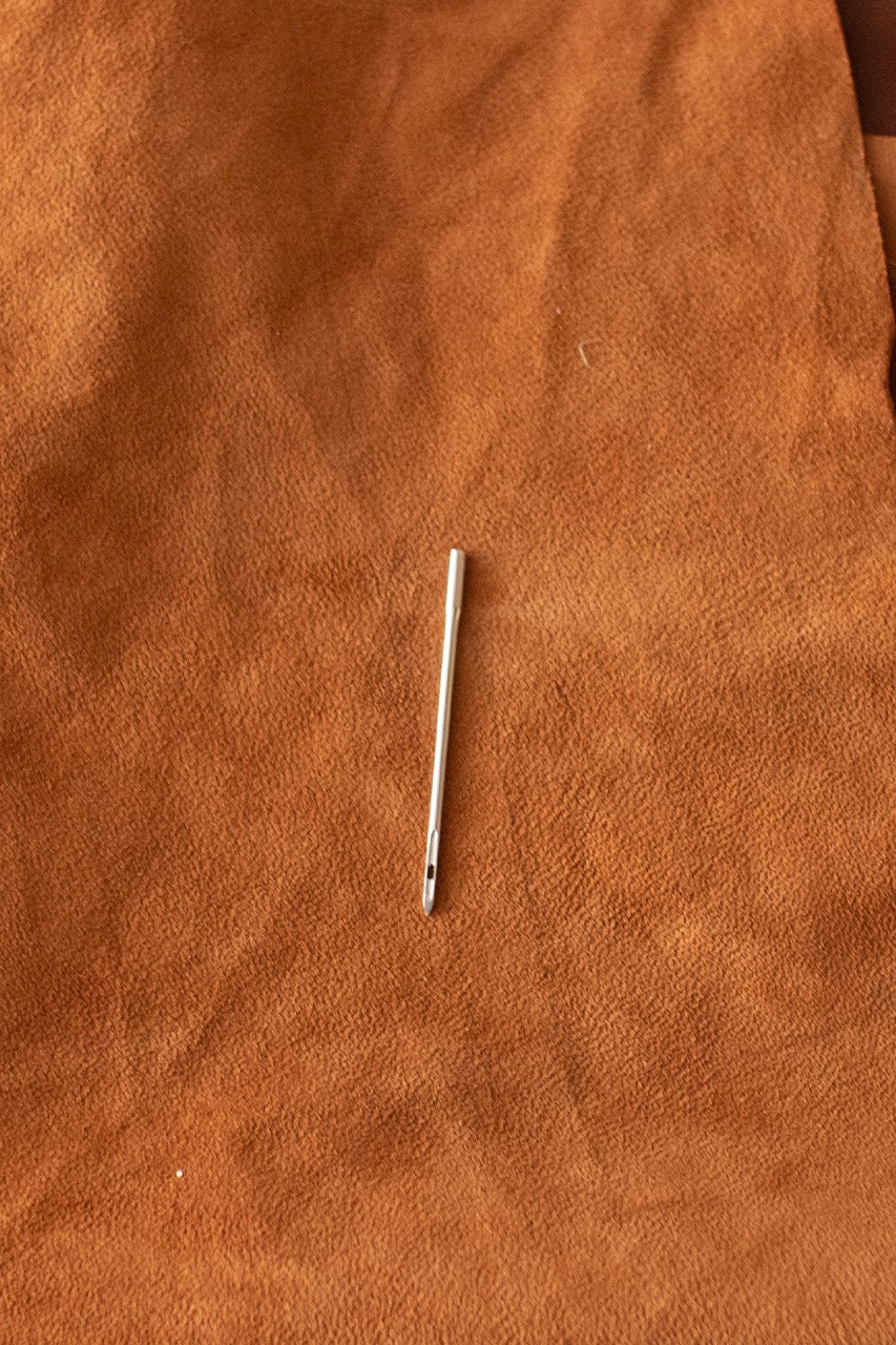 A close-up of a replacement needle designed for sewing awls, showcasing its sharp tip and durable construction.