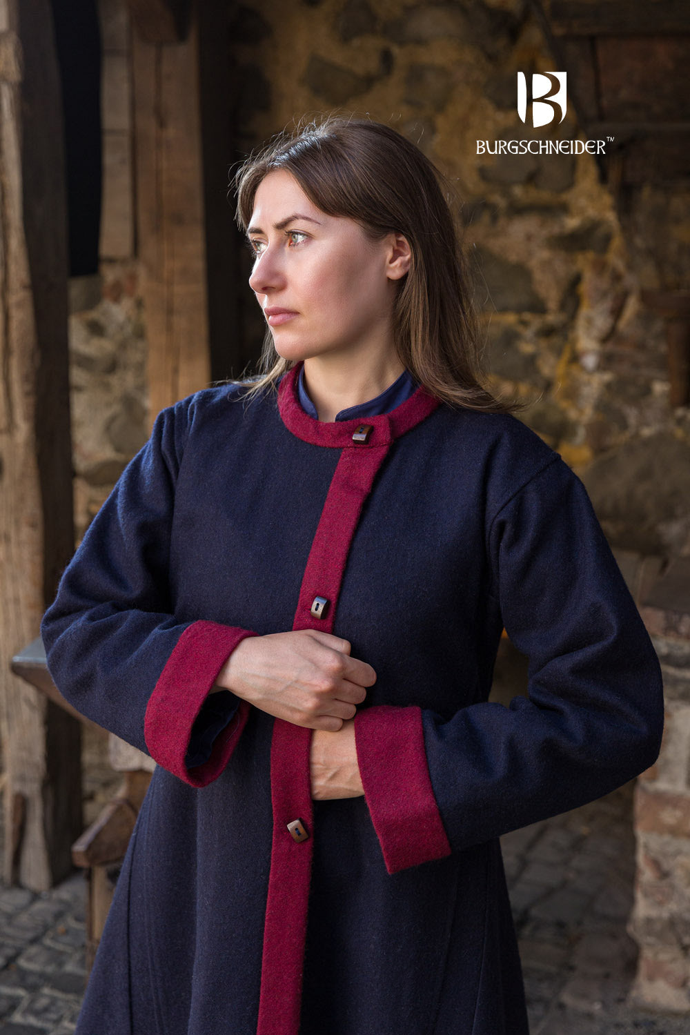 Kseniya Rus Coat featuring a deep blue fabric with vibrant red accents on the collar, cuffs, and hem, adorned with buttons for closure.
