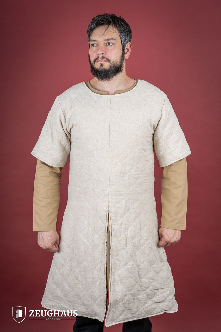 Short Sleeved Gambeson made of soft cotton canvas with light padding, featuring slits for movement and short sleeves for layering.