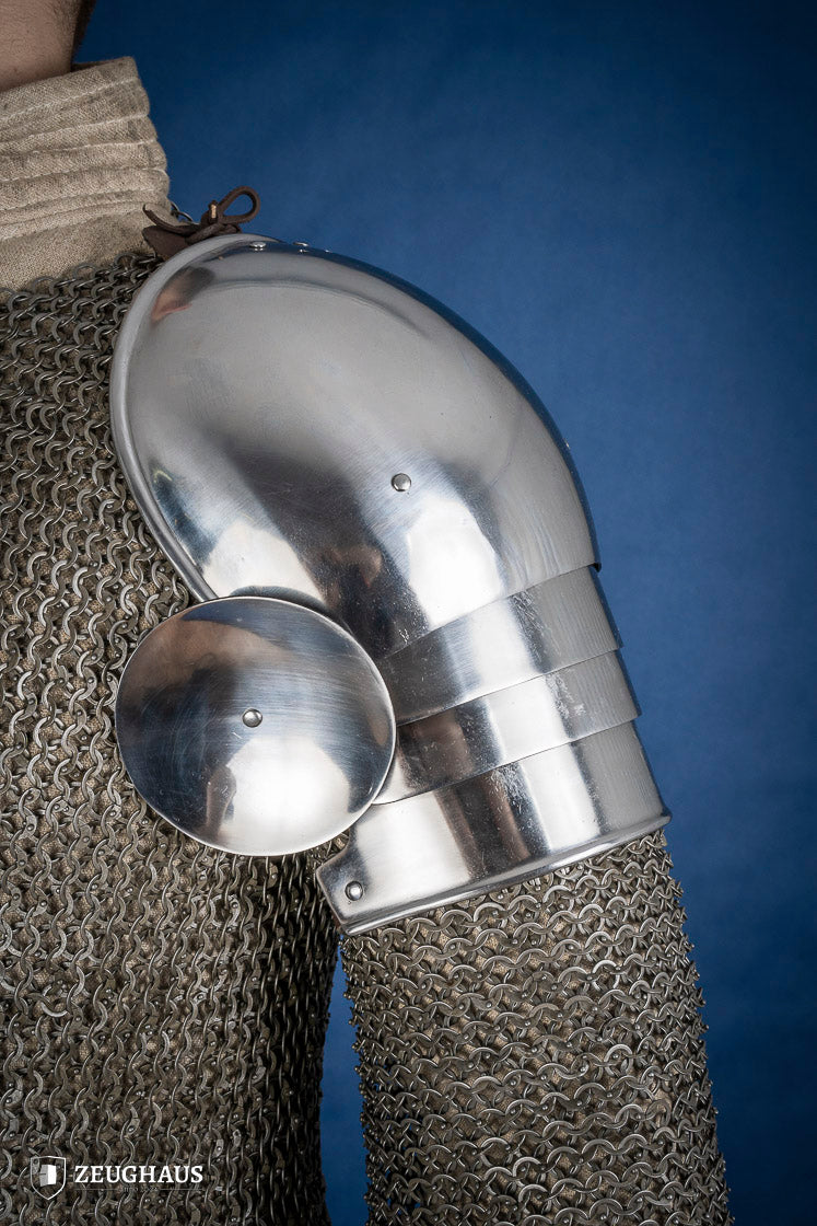 Polished medieval armored shoulders made of 1.6mm steel with a satin finish, showcasing handcrafted details and protective design.