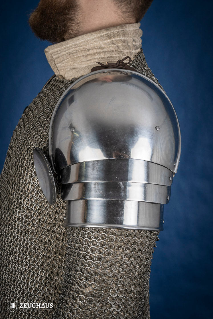 Polished medieval armored shoulders made of 1.6mm steel with a satin finish, showcasing handcrafted details and protective design.