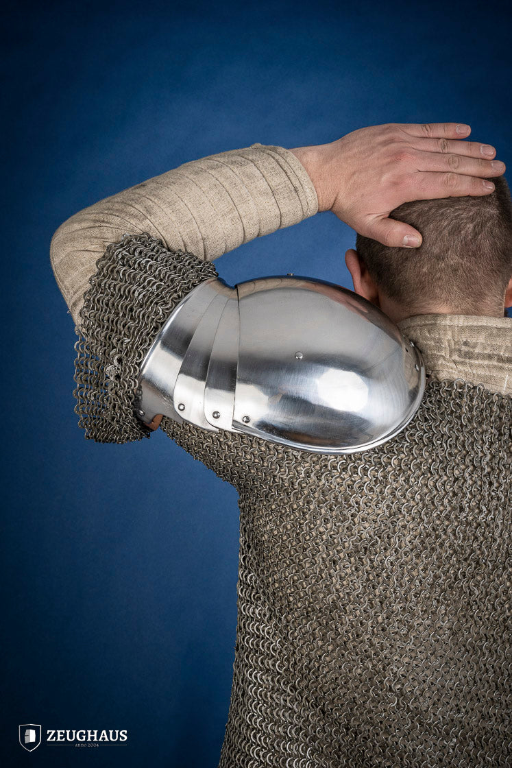 Polished medieval armored shoulders made of 1.6mm steel with a satin finish, showcasing handcrafted details and protective design.