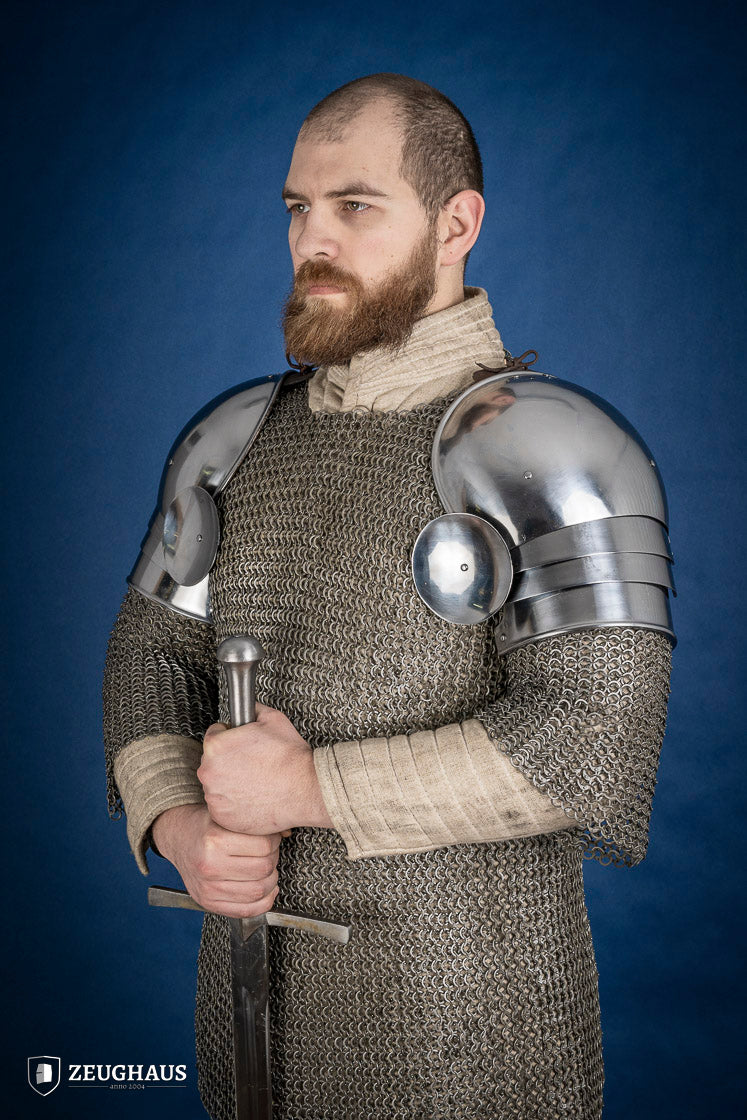 Polished medieval armored shoulders made of 1.6mm steel with a satin finish, showcasing handcrafted details and protective design.