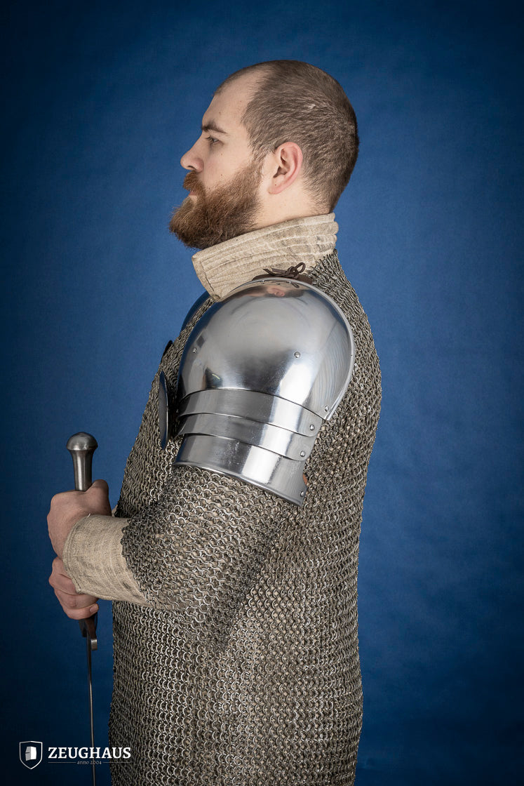 Polished medieval armored shoulders made of 1.6mm steel with a satin finish, showcasing handcrafted details and protective design.