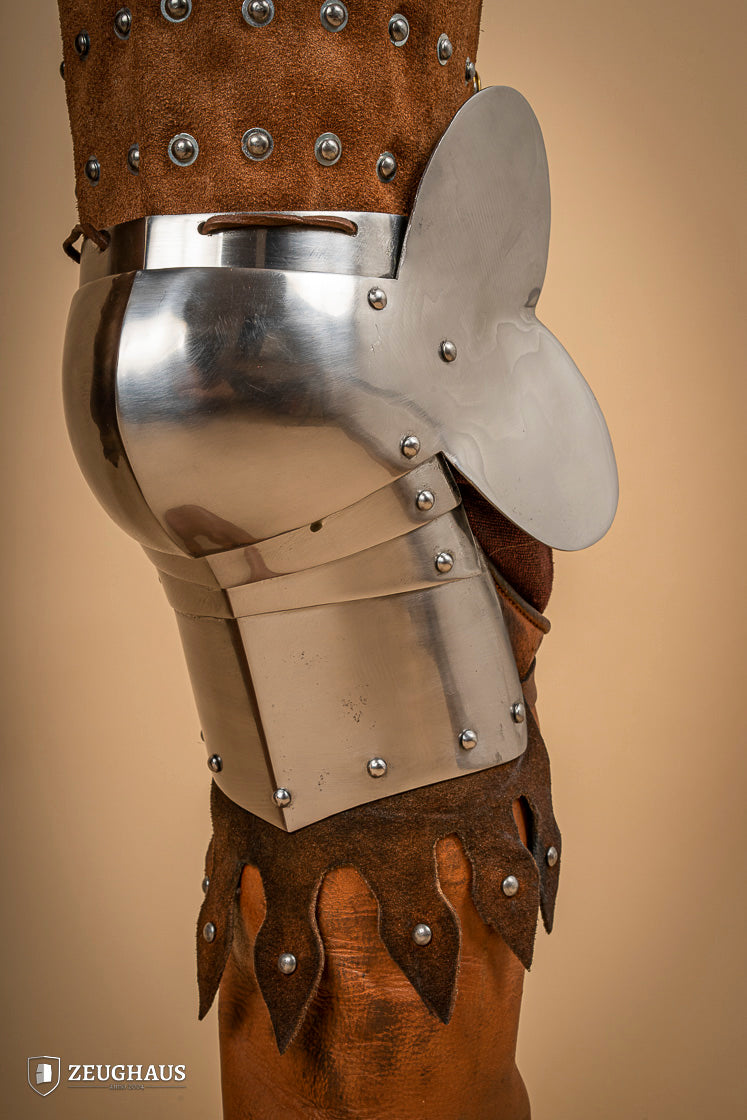 Splinted Leg Armour made of brown suede leather with steel bands, showcasing intricate craftsmanship and medieval design.