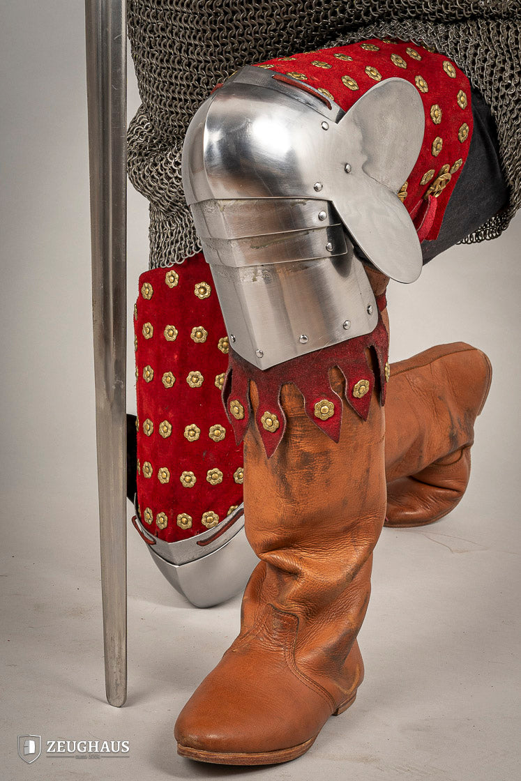 Splinted Leg Armour made of red suede leather with metal bands, showcasing intricate craftsmanship and historical design.