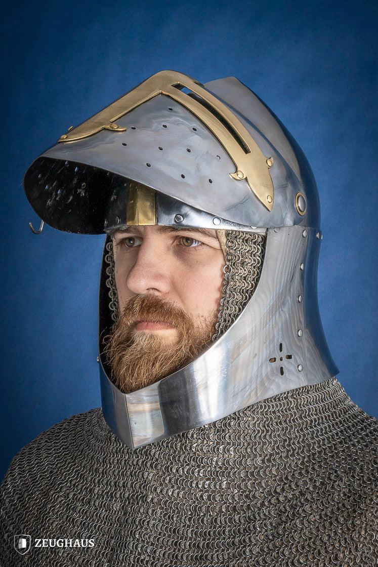 A detailed Sugar Loaf Helmet with a brass visor, showcasing its ornate cross design and steel craftsmanship, perfect for medieval reenactments.