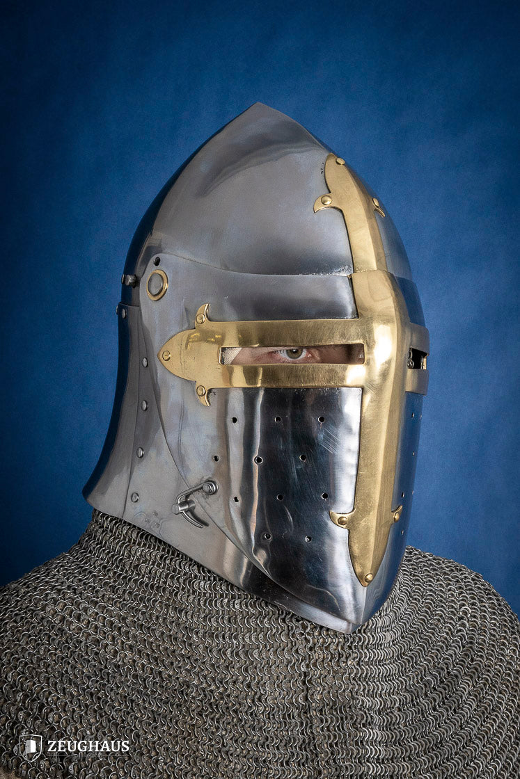 A detailed Sugar Loaf Helmet with a brass visor, showcasing its ornate cross design and steel craftsmanship, perfect for medieval reenactments.