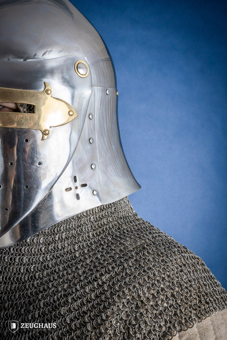 A detailed Sugar Loaf Helmet with a brass visor, showcasing its ornate cross design and steel craftsmanship, perfect for medieval reenactments.