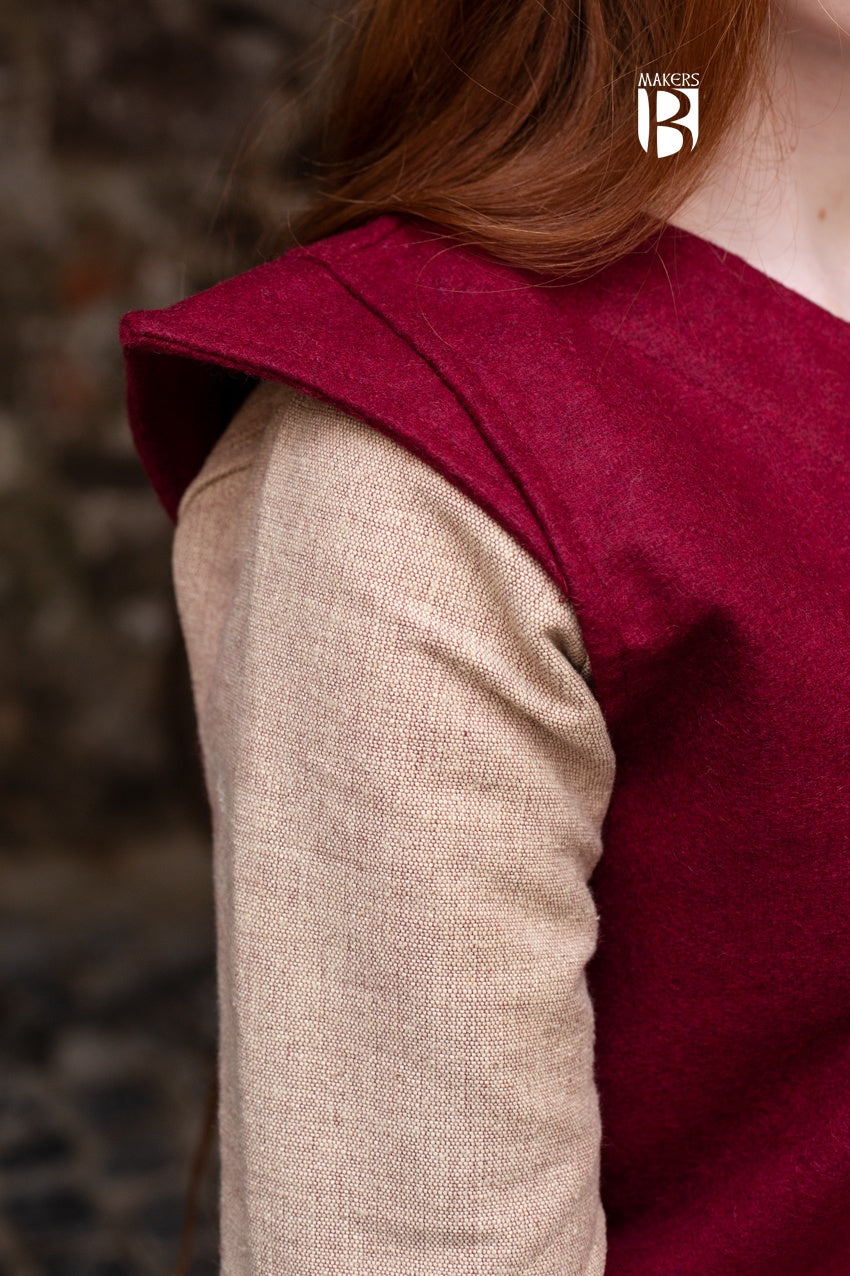 A vibrant red tunic made of robust wool felt, featuring wide sleeve holes and elegant slits for freedom of movement, perfect for adventurers.