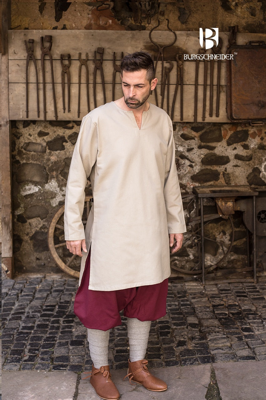 A medieval under tunic made of coarse natural cotton, featuring long sleeves, a round neckline, and side slits for comfort.