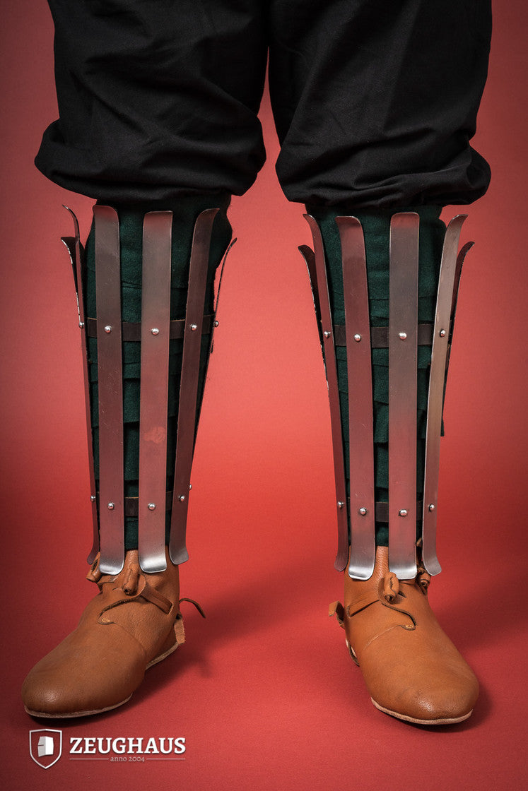 Polished Viking Greaves made from 1.6mm steel, featuring adjustable straps for a flexible fit, showcasing historical craftsmanship.