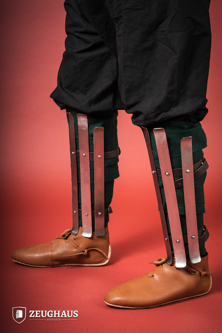 Polished Viking Greaves made from 1.6mm steel, featuring adjustable straps for a flexible fit, showcasing historical craftsmanship.