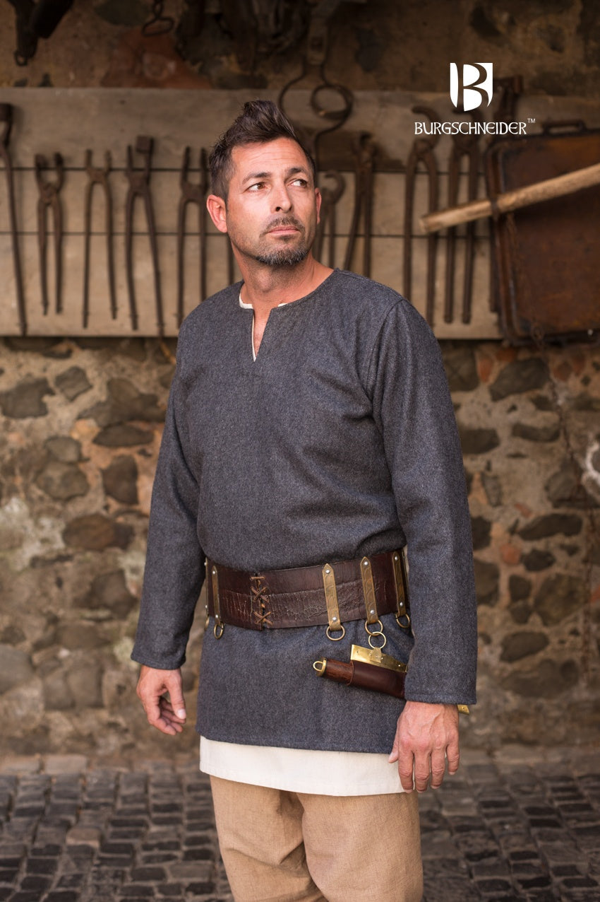 Dark grey wool tunic Lodin with long sleeves, side slits, and round neckline, styled with a brooch.