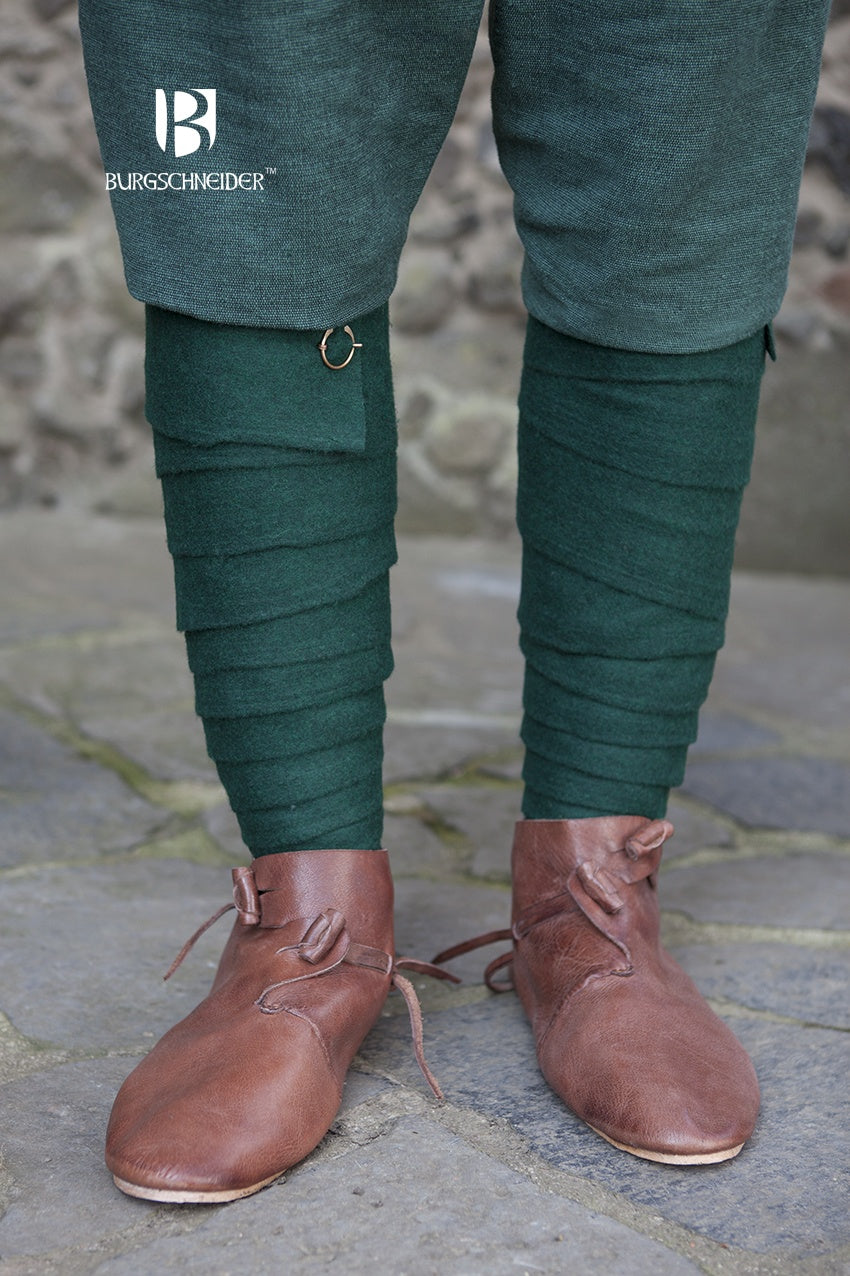 A pair of green wool winingas, traditional leg wraps inspired by Iron Age designs, showcasing their length and texture.