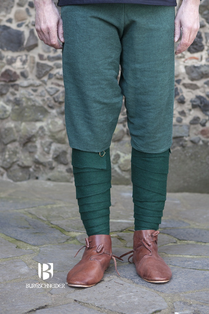 A pair of green wool winingas, traditional leg wraps inspired by Iron Age designs, showcasing their length and texture.