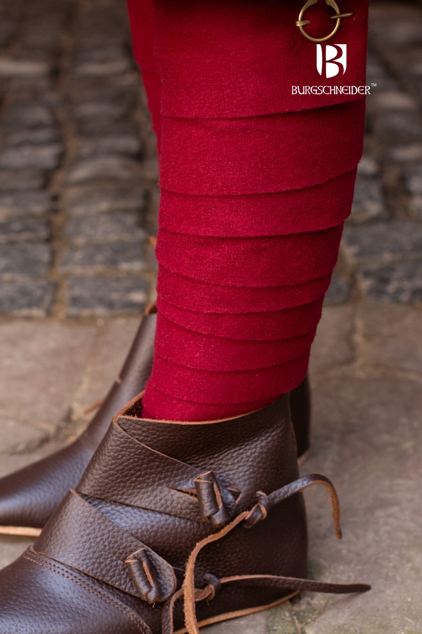 A pair of traditional red wool winingas, showcasing their length and texture, perfect for historical wear.