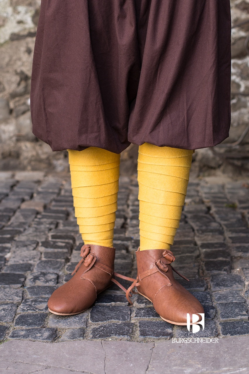 A pair of vibrant yellow Wool Winingas Aki, showcasing their traditional design and high-quality wool material, perfect for historical reenactments.