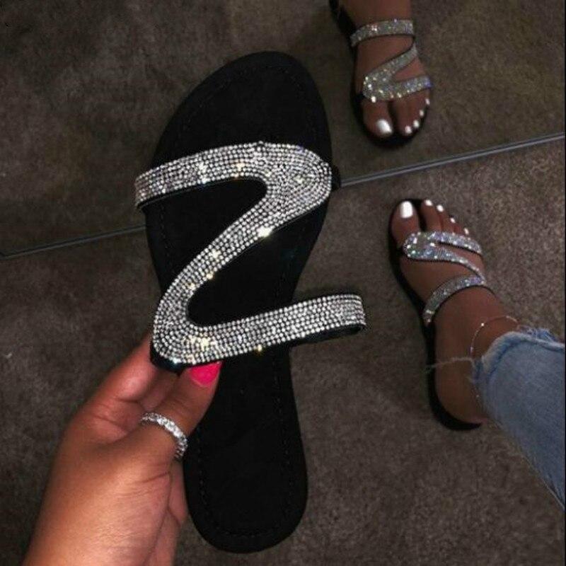 A pair of stylish 2021 Bling Bling Slides for women, featuring a shimmering design perfect for summer beach outings, displayed on a sandy background.