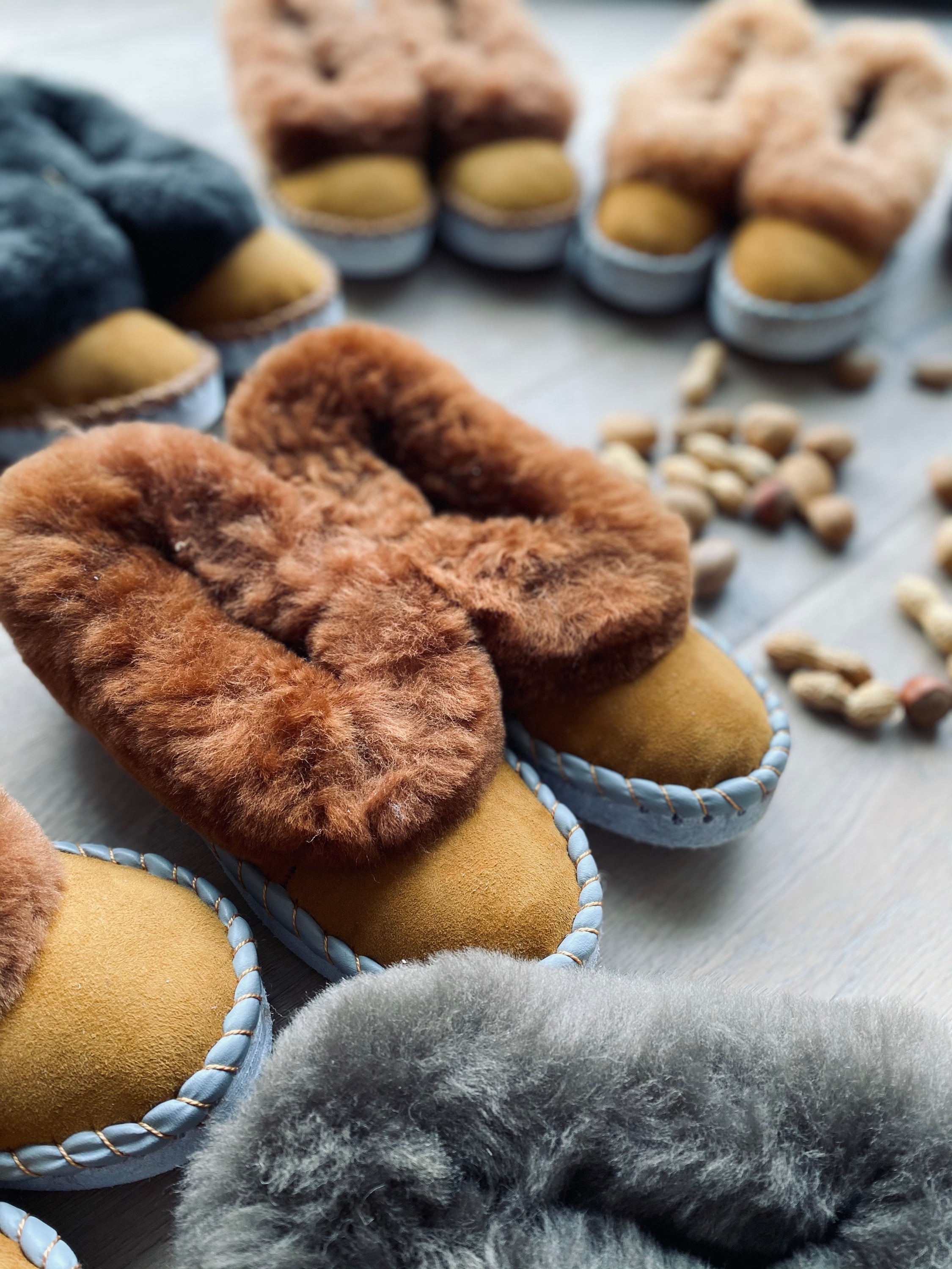 Brown Range Sheepskin Slippers featuring a fluffy fur cuff and genuine leather sole, showcasing their handcrafted quality and cozy design.