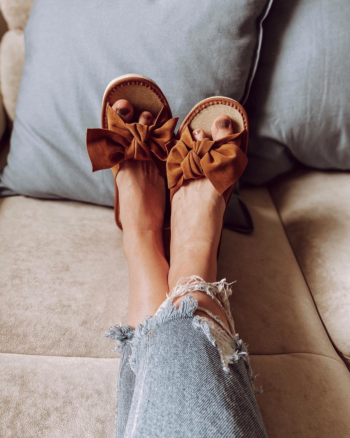 Brown suede slippers featuring a stylish ribbon front and cushioned insole, perfect for warm weather.