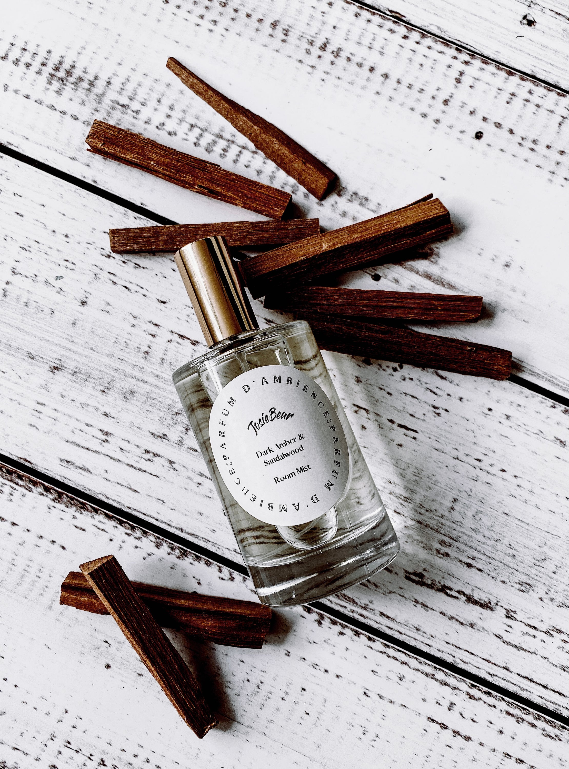 Dark Amber & Sandalwood Room Mist in an elegant glass bottle, showcasing its rich earthy color and luxurious design.