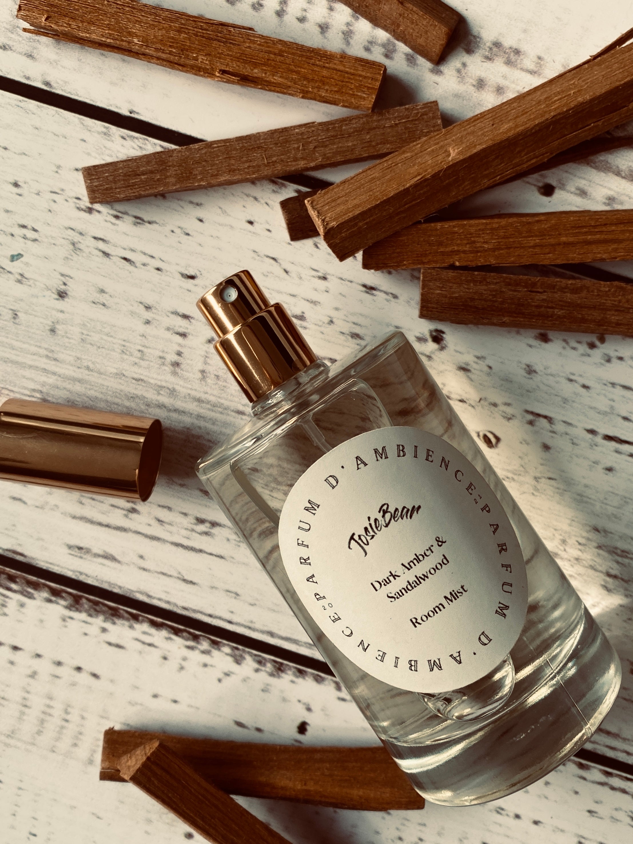 Dark Amber & Sandalwood Room Mist in an elegant glass bottle, showcasing its rich earthy color and luxurious design.