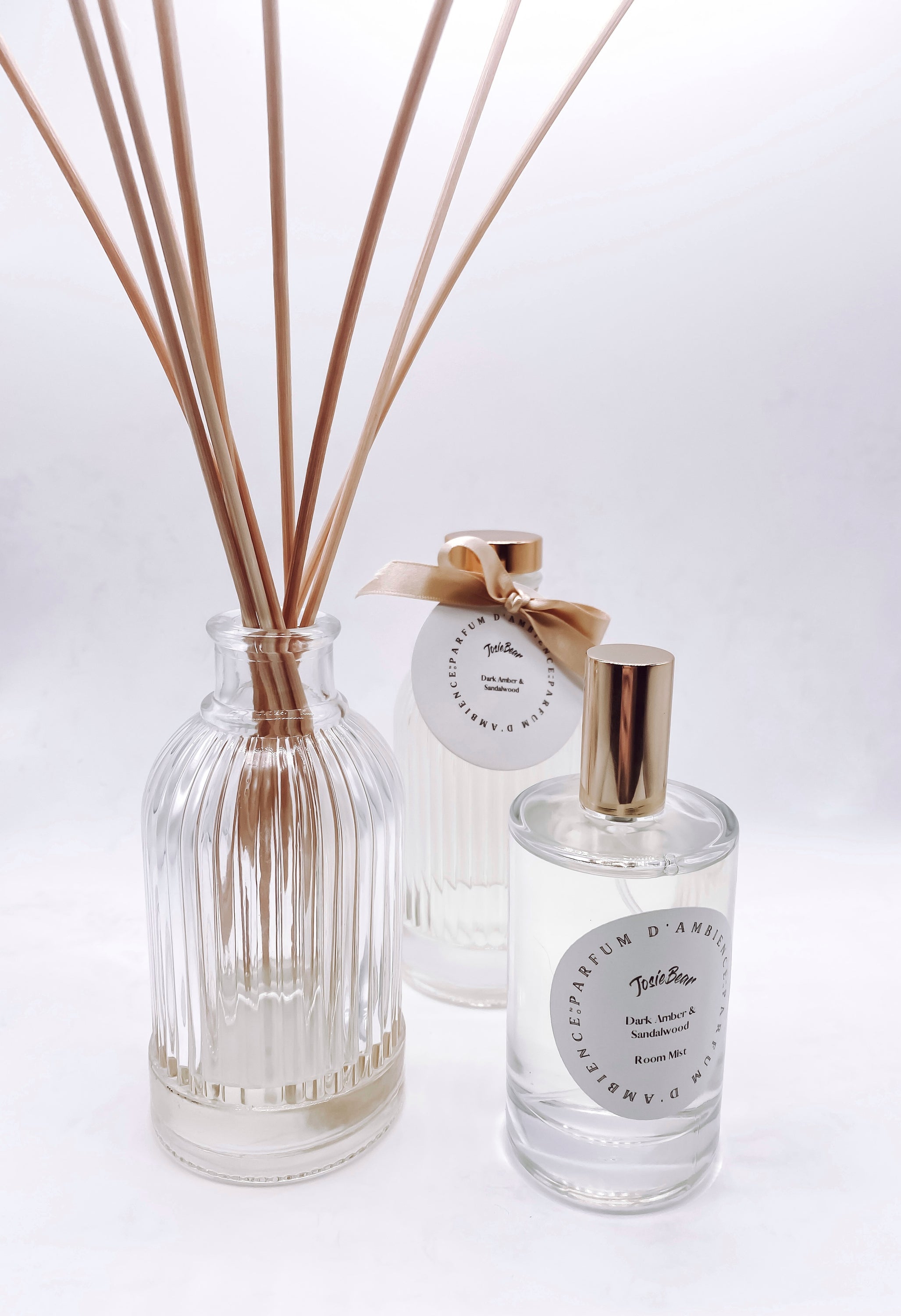 Dark Amber & Sandalwood Room Mist in an elegant glass bottle, showcasing its rich earthy color and luxurious design.