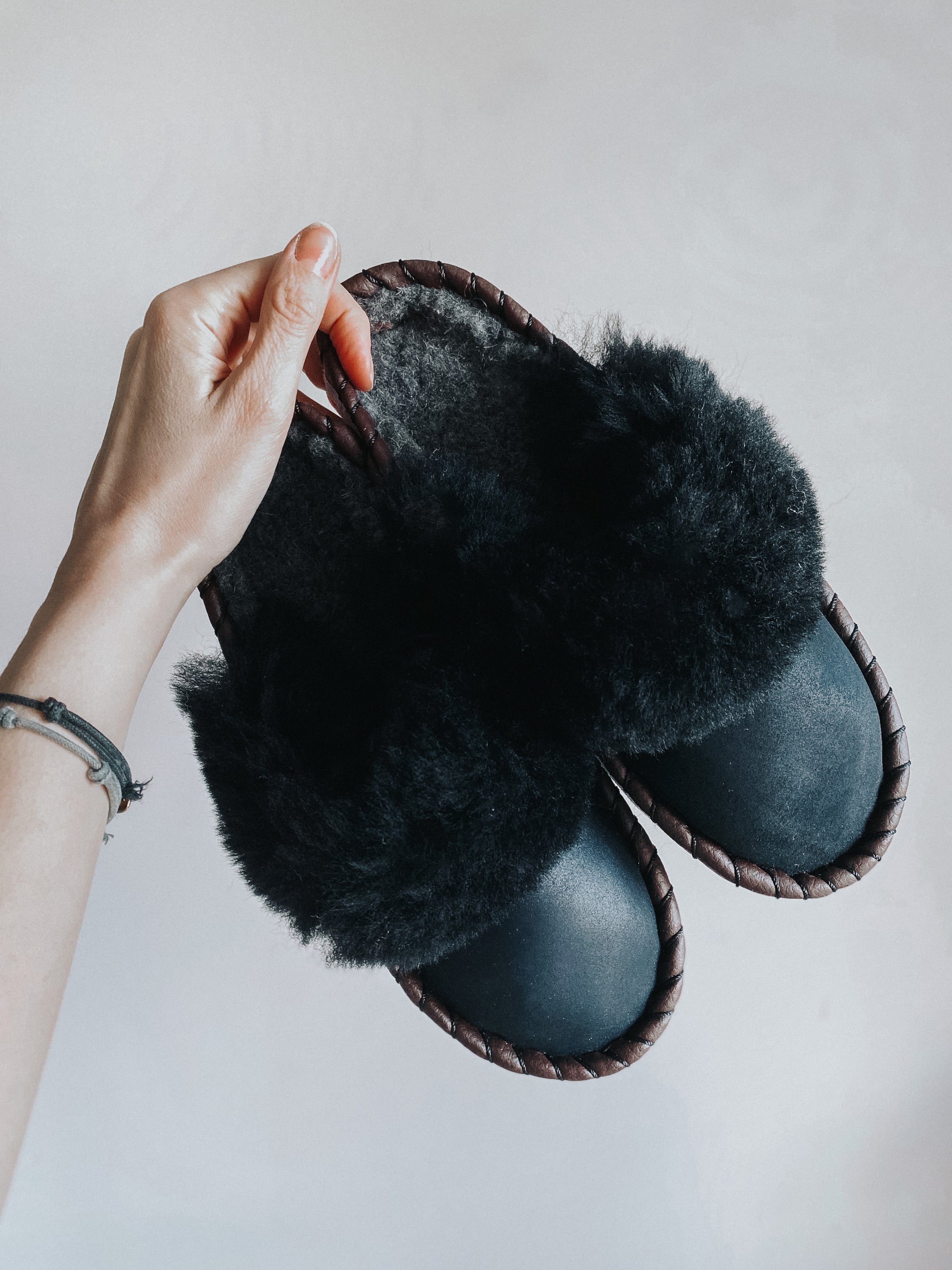 Onyx Black Slip Ons featuring black leather and fur cuff, showcasing luxurious craftsmanship and cozy design.