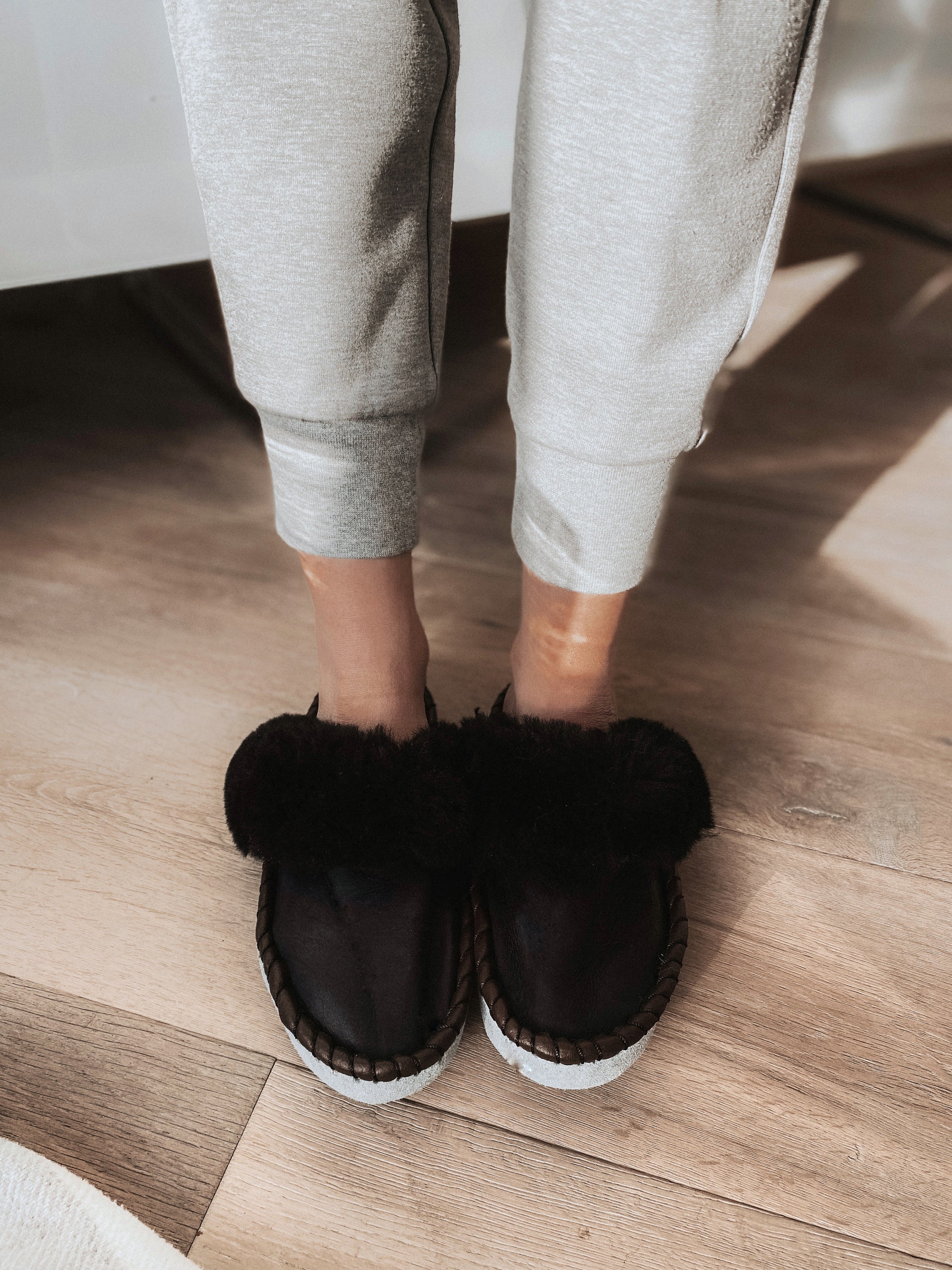 Onyx Black Slip Ons featuring black leather and fur cuff, showcasing luxurious craftsmanship and cozy design.