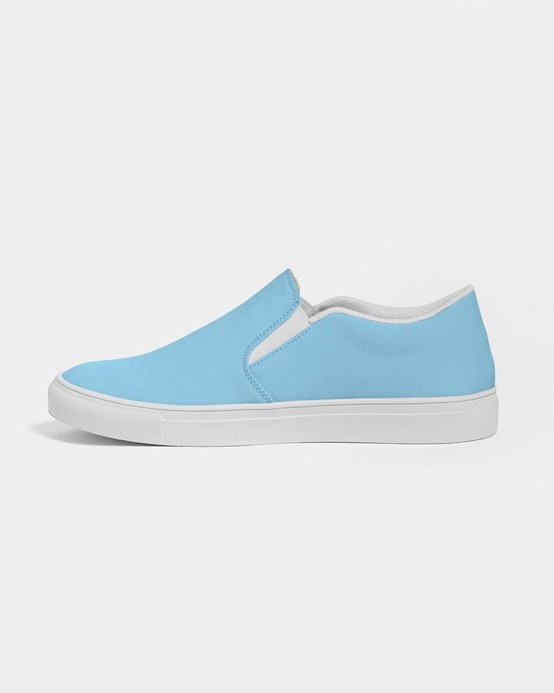 A pair of women's light blue low top slip-on canvas sneakers with elastic side accents and a padded collar, perfect for casual wear.