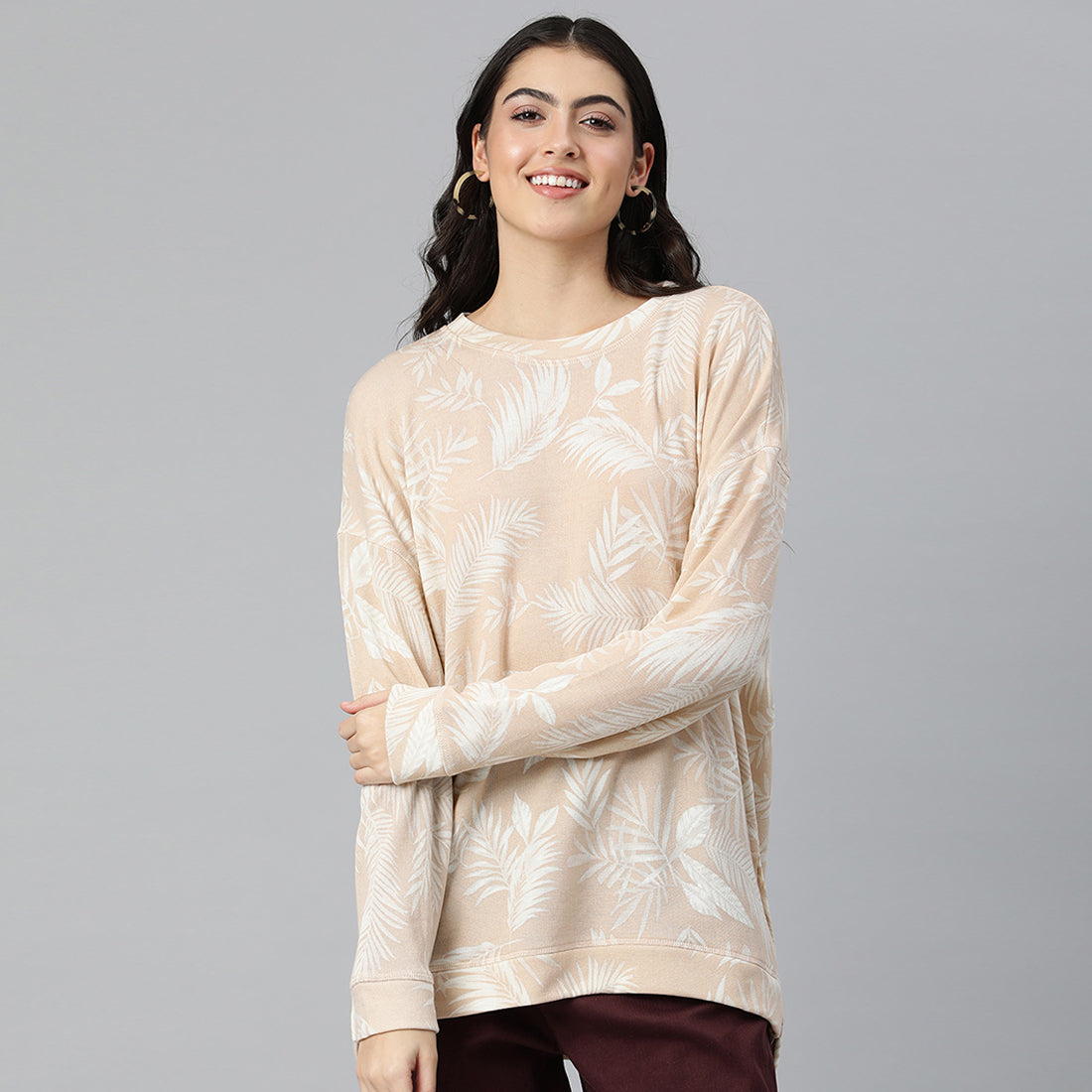 Beige oversized fleece tunic with crew neckline and drop shoulders, featuring an all-over printed design.